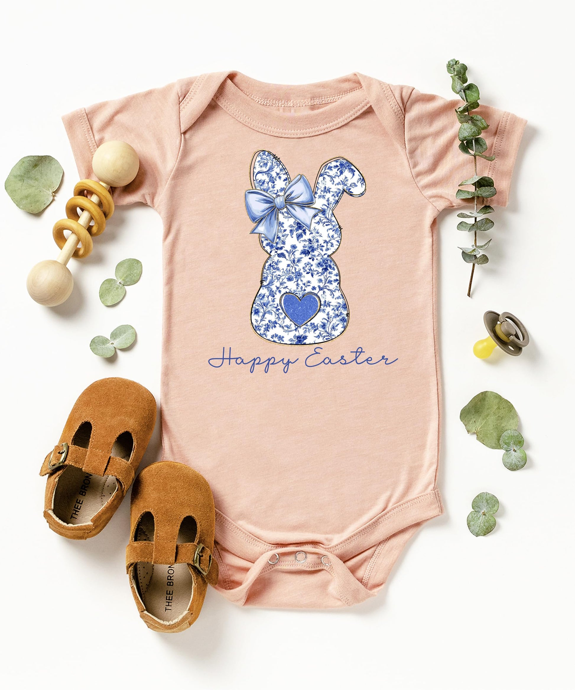 Side view of baby wearing blue floral chinoiserie Easter bodysuit with bow detail