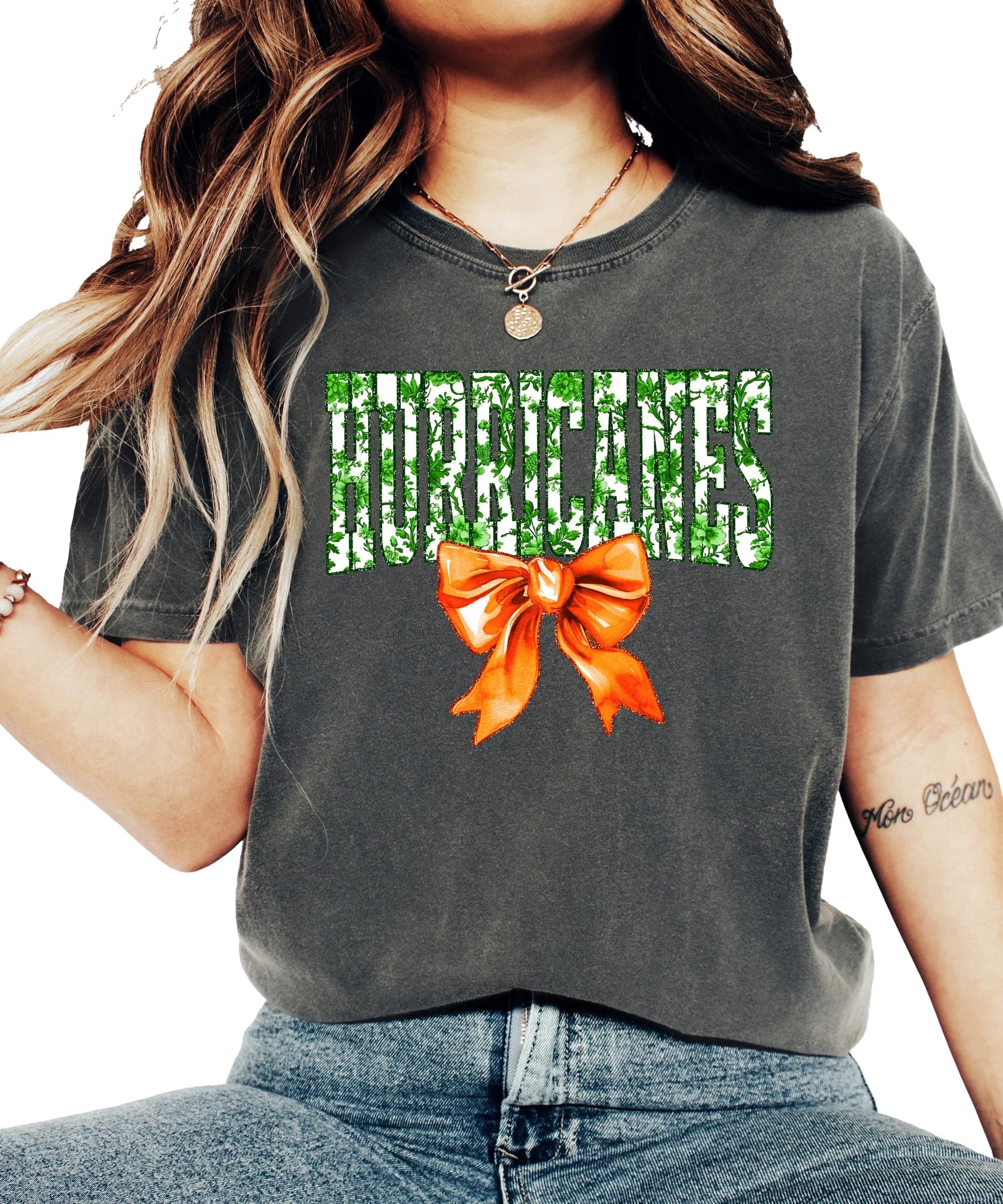 Side or lifestyle view of women's ivory Hurricanes floral graphic tee with orange bow detail