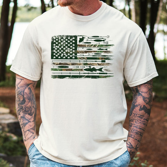 Close-up of American flag fishing pole and lure graphic print on ivory men's tee from Olive Loves Apple