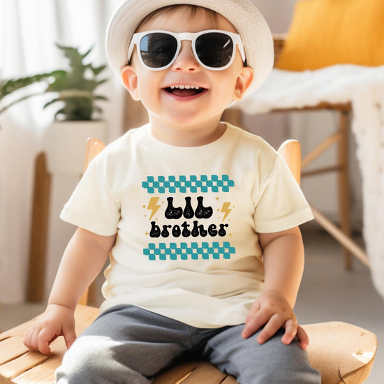 Little brother shirt and bodysuit flat lay for sibling reveal baby announcement