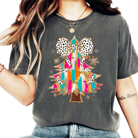 Flat lay of seafoam holiday graphic tee featuring glitter Christmas tree and coquette bow design
