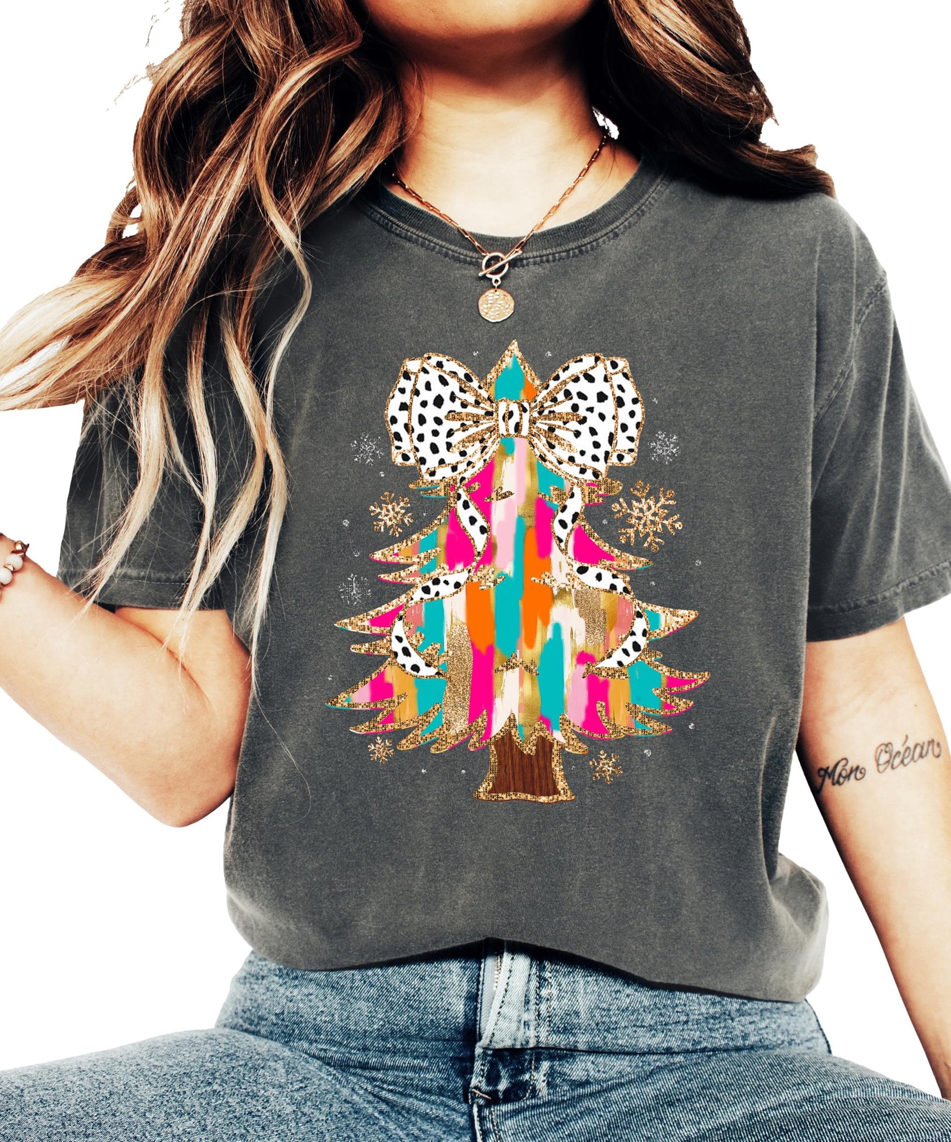 Flat lay of seafoam holiday graphic tee featuring glitter Christmas tree and coquette bow design