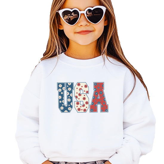 Close-up of floral USA print on white sweatshirt showing vibrant red white and blue colors
