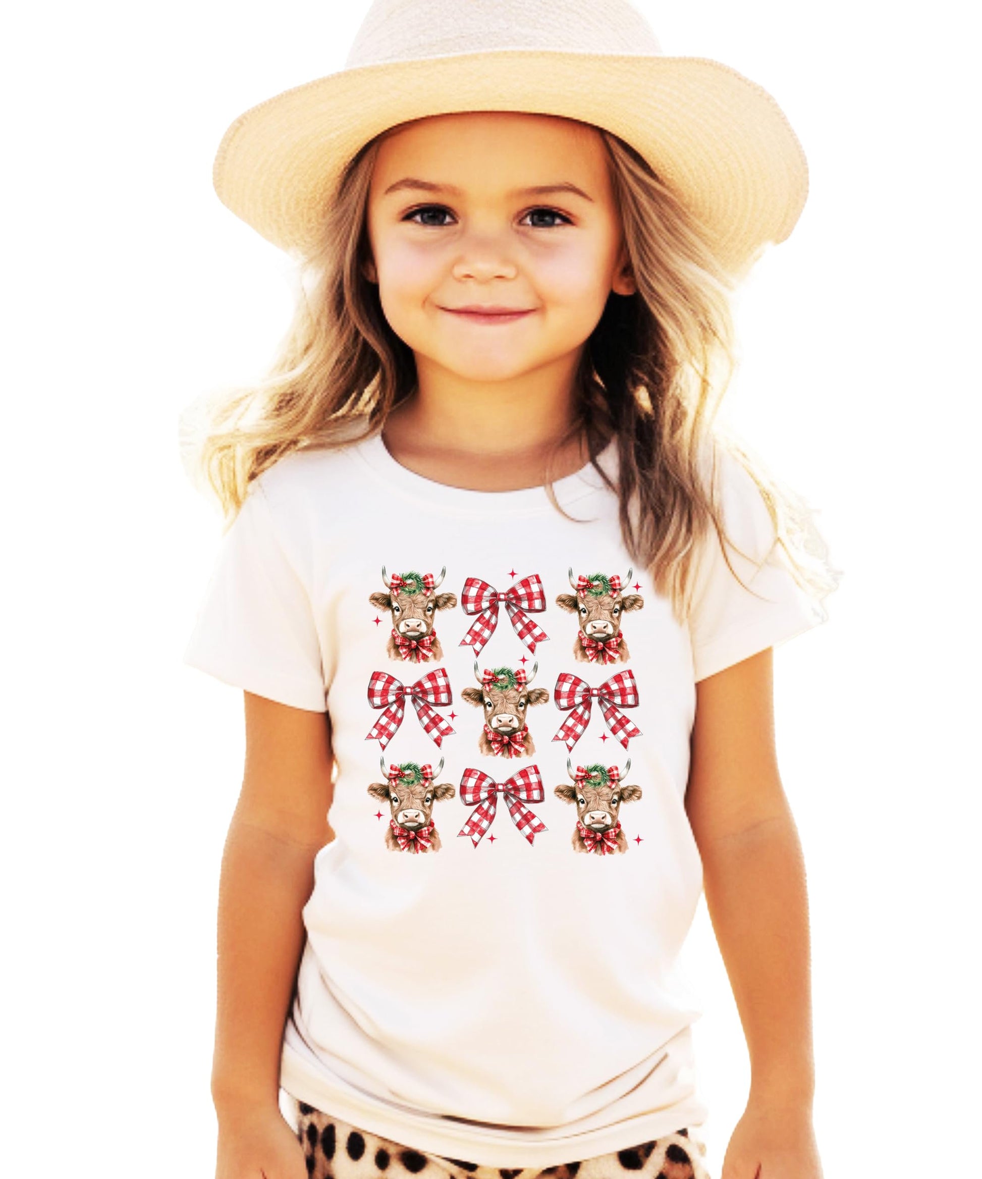 Flat lay of women's festive winter graphic tee with Christmas cow and plaid bow design