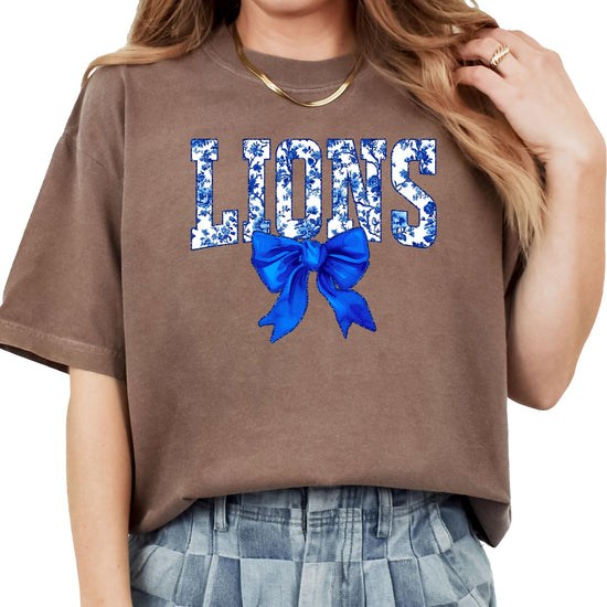 Flat lay of ivory Lions t-shirt displaying full floral bow design