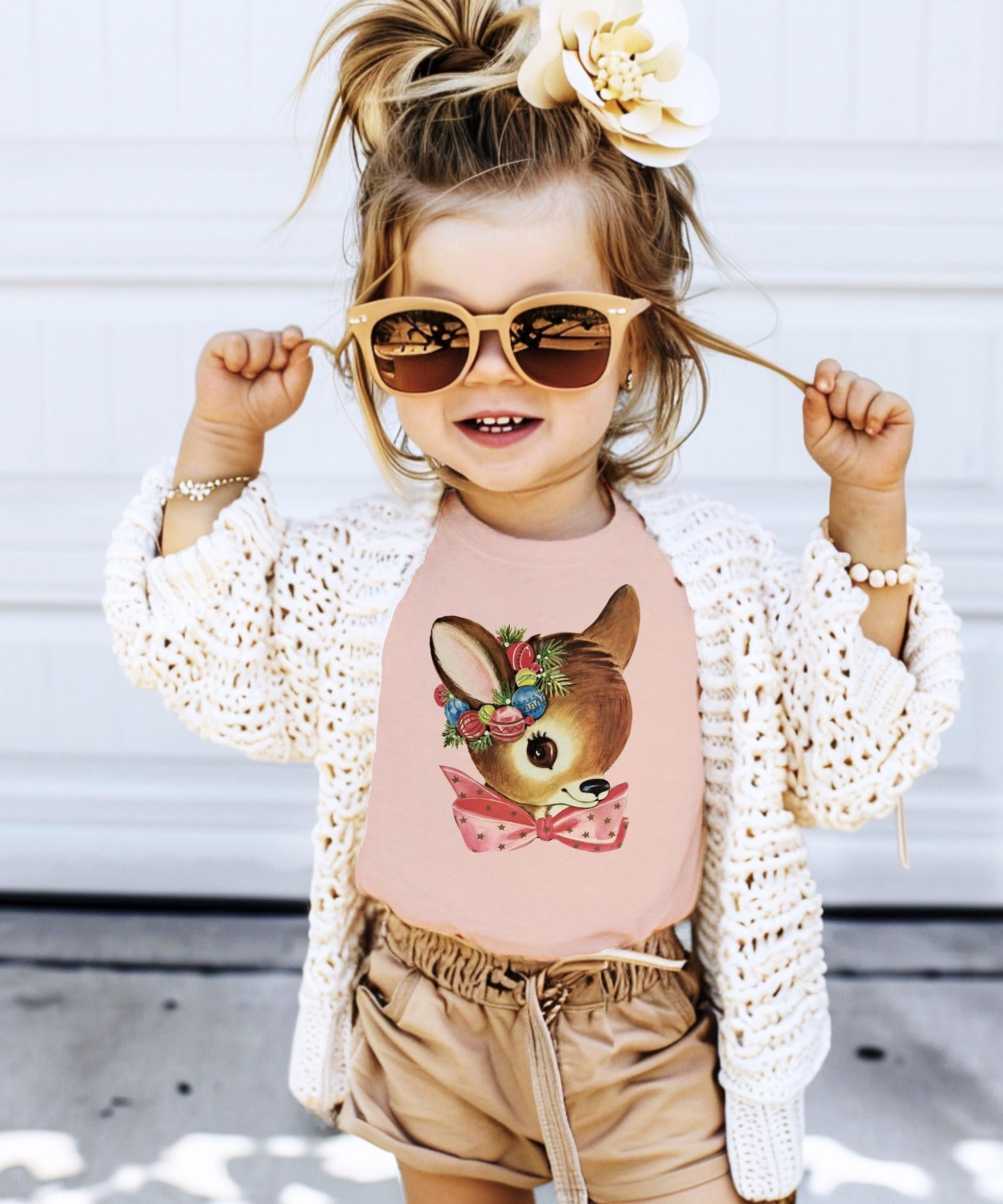 Flat lay of Olive Loves Apple toddler reindeer wreath Christmas tee in peach color