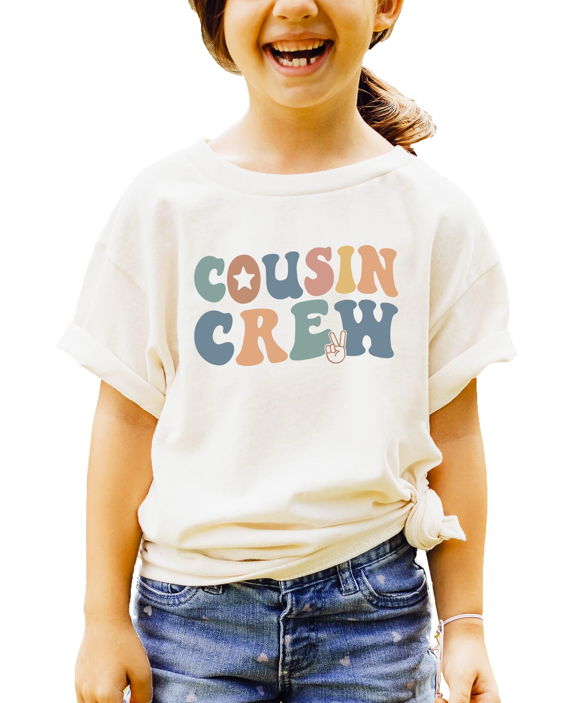 Close-up view of vibrant rainbow colored Cousin Crew lettering on natural tee