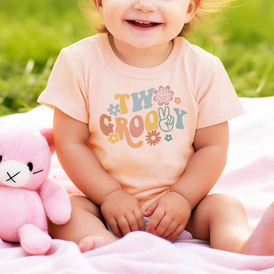 Side view of toddler wearing Two Groovy daisy birthday shirt showing comfortable fit