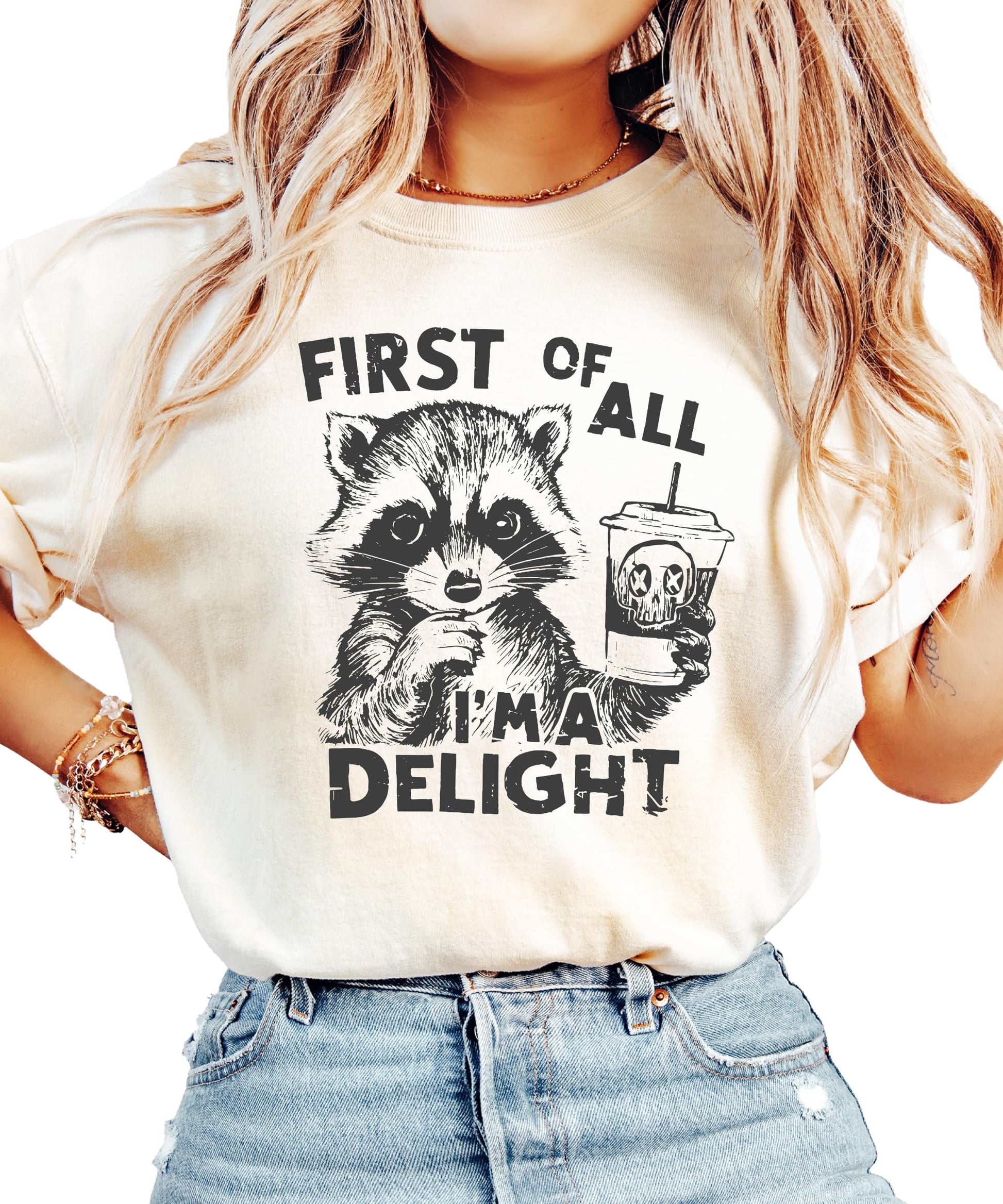 Ivory unisex graphic tee with a raccoon holding a drink and the phrase First of All I'm a Delight