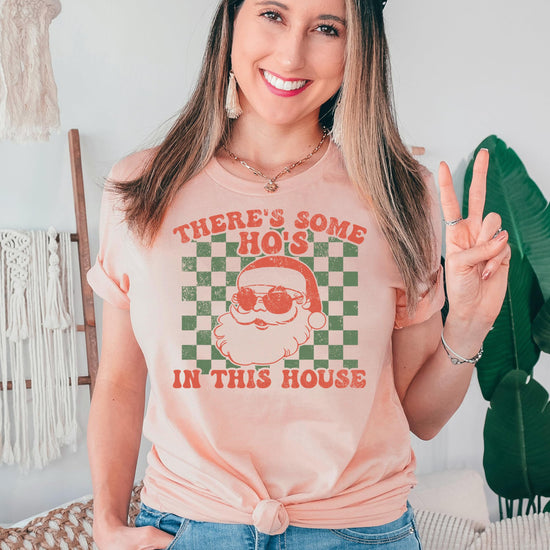 Adult wearing a funny Christmas party shirt with There's Some Ho's in This House graphic