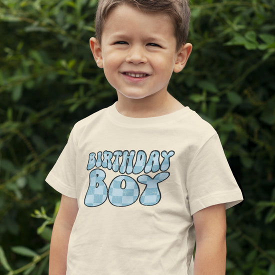 Detail shot of high-quality groovy birthday boy print on black toddler graphic tee