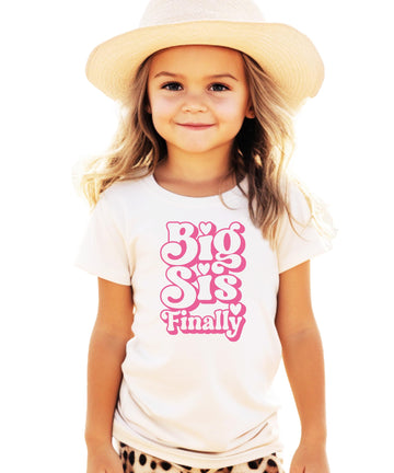 Girls Big Sis Finally graphic tee with groovy pink bubble letters and heart details