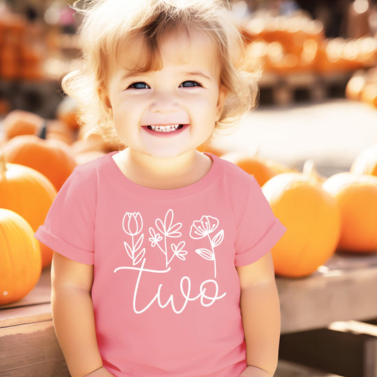Back view of mauve toddler birthday shirt with floral Two cursive design