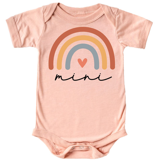 Close-up of vibrant rainbow heart cursive graphic print on peach mommy and me matching shirt