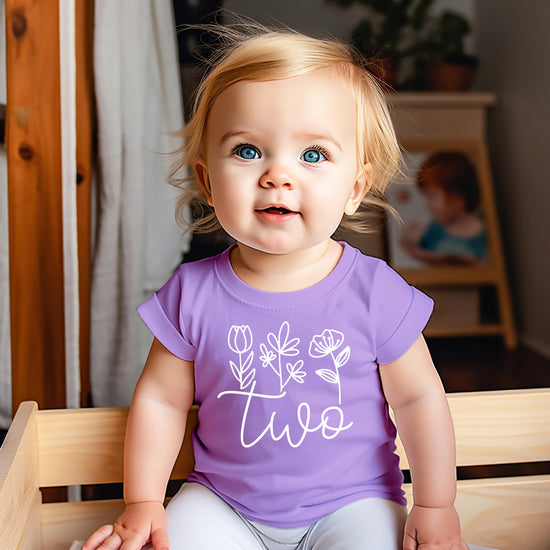 Product detail shot of white floral cursive Two design on mauve toddler tee