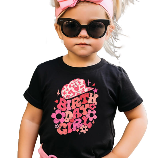 Little girl wearing groovy cowgirl birthday outfit natural graphic tee