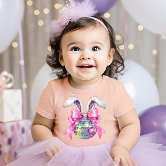 Detail shot of fluffy bunny ears and pink bow graphic on kids Easter graphic tee