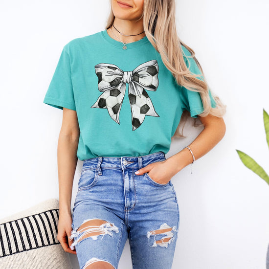 Detail shot of high-quality coquette bow soccer print on seafoam women's tee
