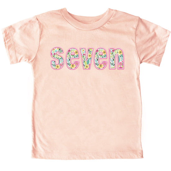 Girls 7th birthday shirt flat lay showing full design and peach color