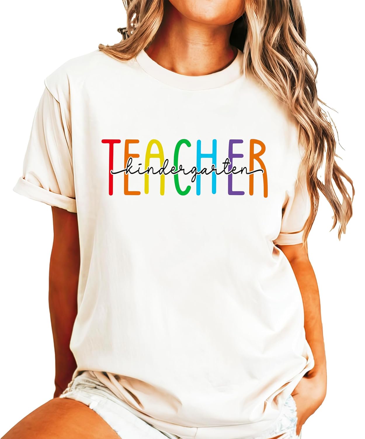 Close-up of rainbow TEACHER design with kindergarten script lettering on pink cotton tee