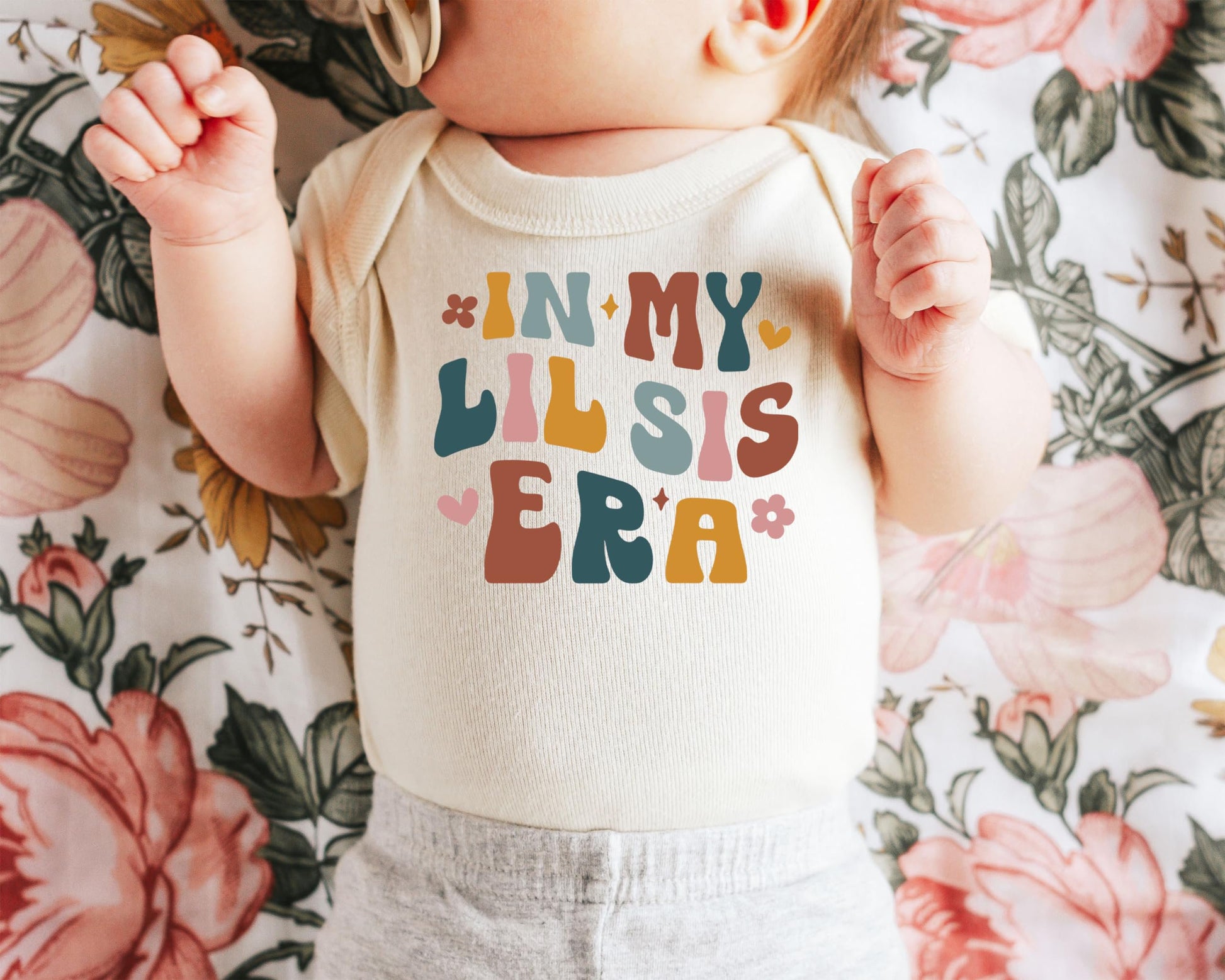 Olive Loves Apple Little Sister Era bodysuit shown on infant, lifestyle photo