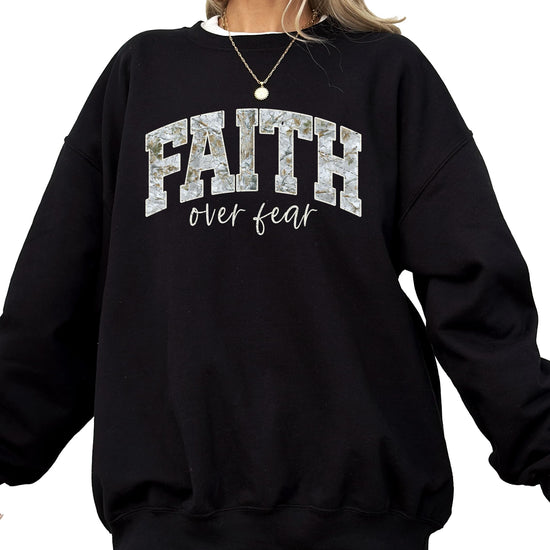Front view of Faith Over Fear graphic sweatshirt in army green on model