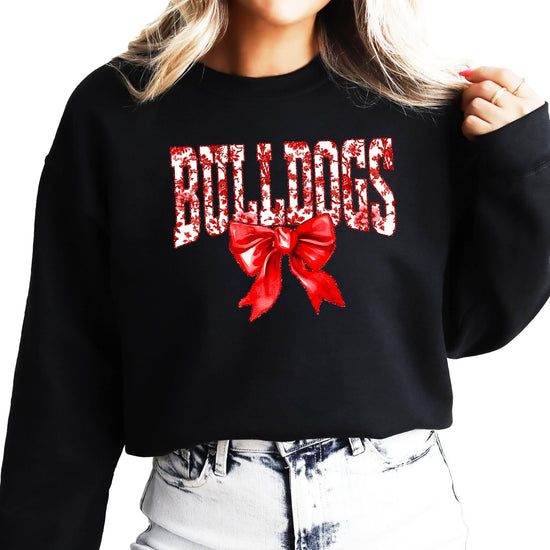 Woman wearing black Bulldogs spirit sweatshirt with red bow