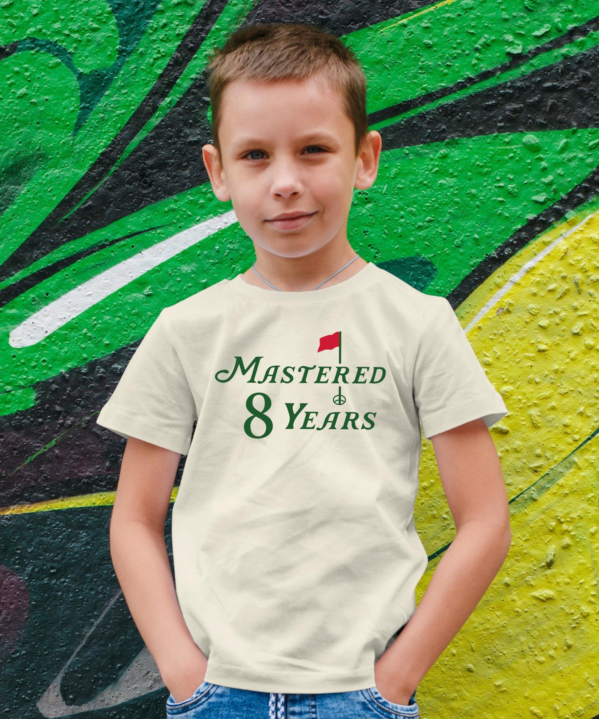 Boys and girls golf themed 8th birthday t-shirt in natural color laid flat