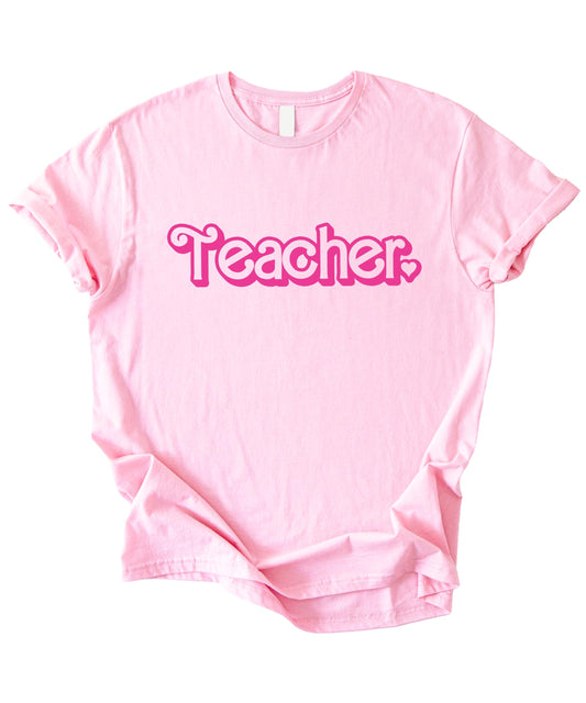 Front view of pink Teacher shirt with heart graphic on women's relaxed fit tee