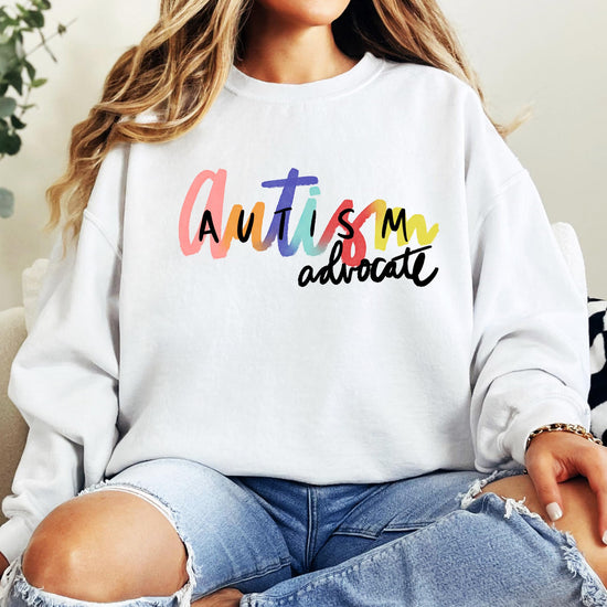 Olive Loves Apple Autism Advocate women's sweatshirt laid flat showing full colorful design