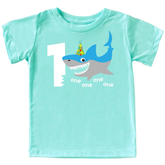 Flat lay of shark themed first birthday shirt for baby boys