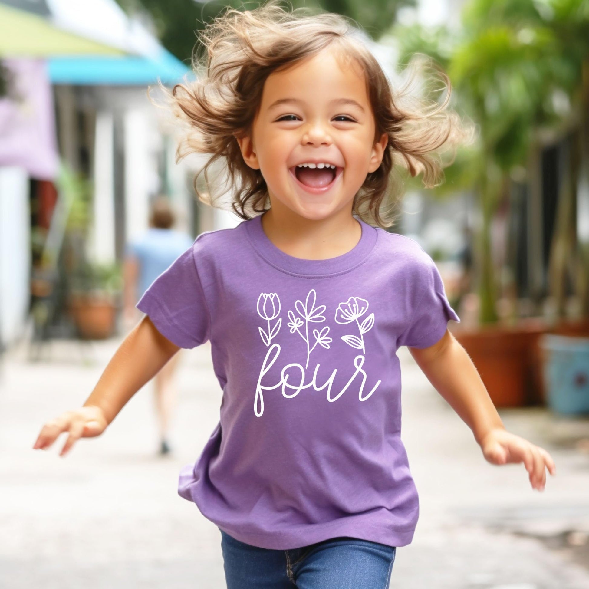Flat lay of girls fourth birthday floral graphic tee in purple