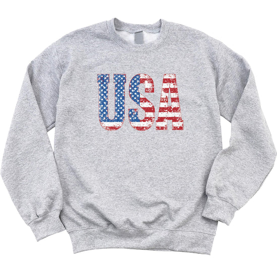 Model wearing distressed USA flag sweatshirt, casual patriotic outfit