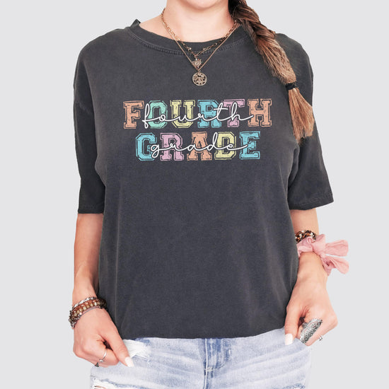 Fourth Grade teacher t-shirt laid flat showing vibrant pastel font design