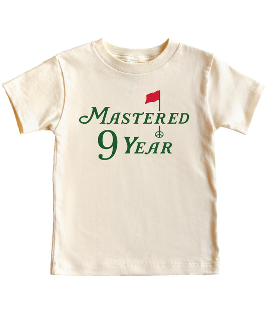 Youth golf birthday tee laid flat showing full graphic design in natural colorway