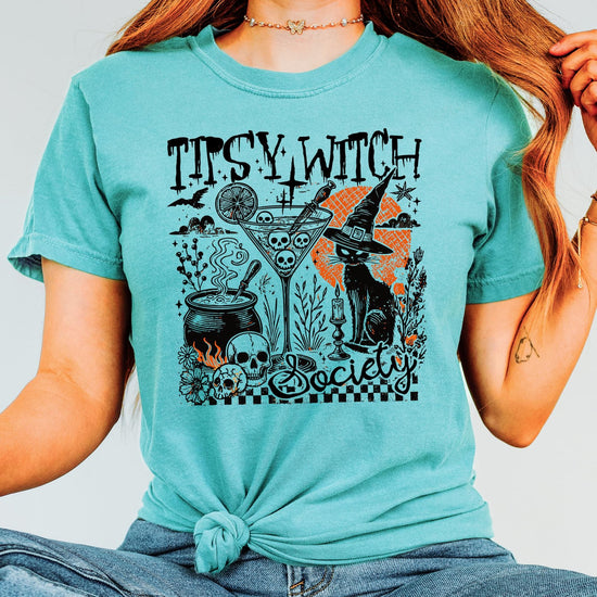 Tipsy Witch Society Halloween graphic tee styled for fall season, featuring spooky black cat and cocktail design