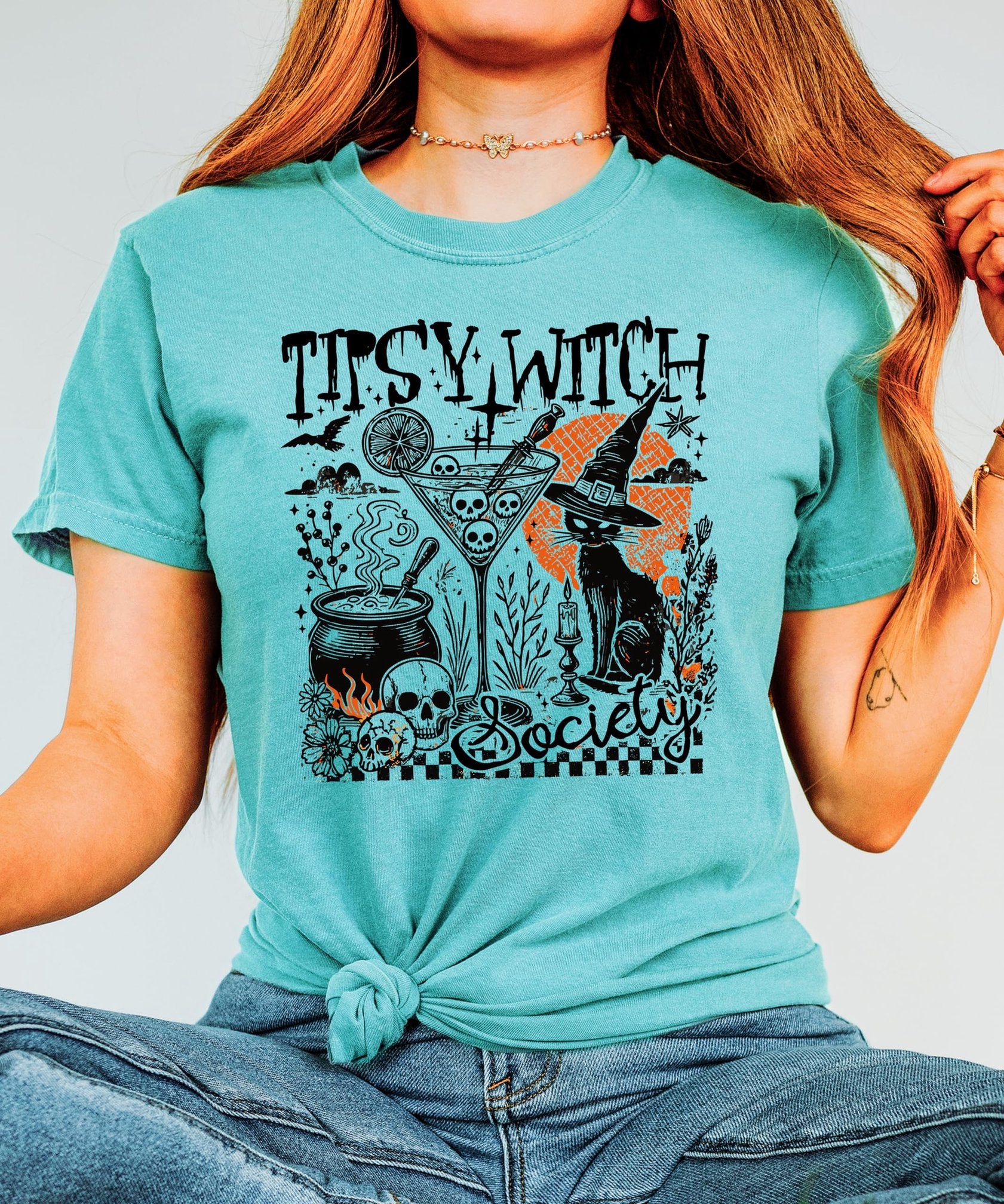 Tipsy Witch Society Halloween graphic tee styled for fall season, featuring spooky black cat and cocktail design