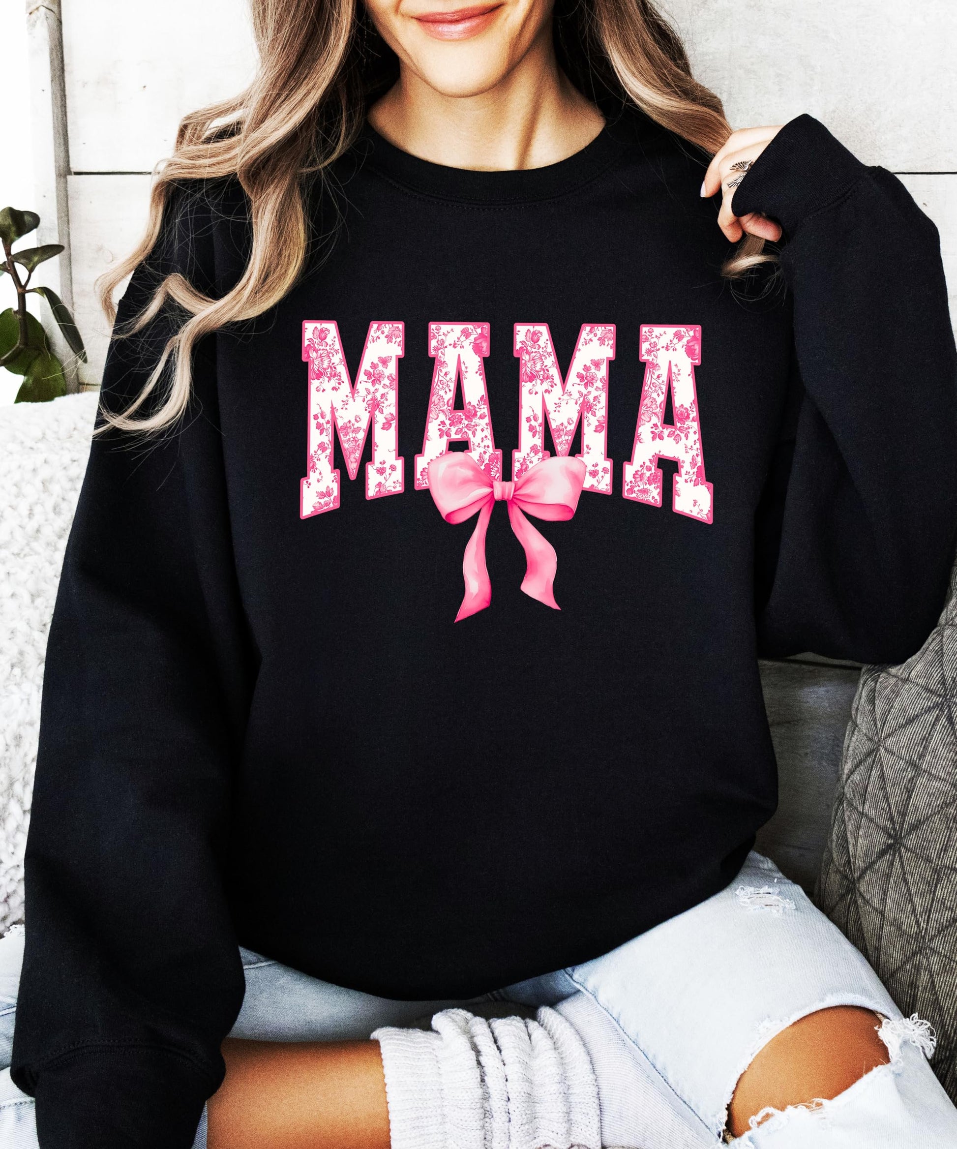 Detail shot of soft black sweatshirt fabric with pink bow MAMA print