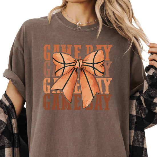 Close-up view of coquette bow basketball graphic on women's tee