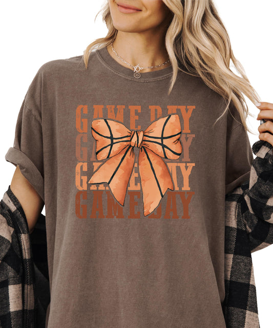 Close-up view of coquette bow basketball graphic on women's tee