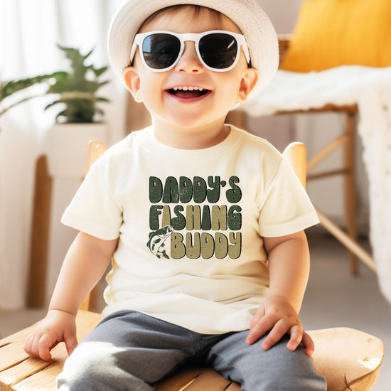 Front view of kids fishing graphic t-shirt laid flat on natural background