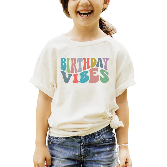 Close-up of Birthday Vibes groovy print on peach girls birthday shirt