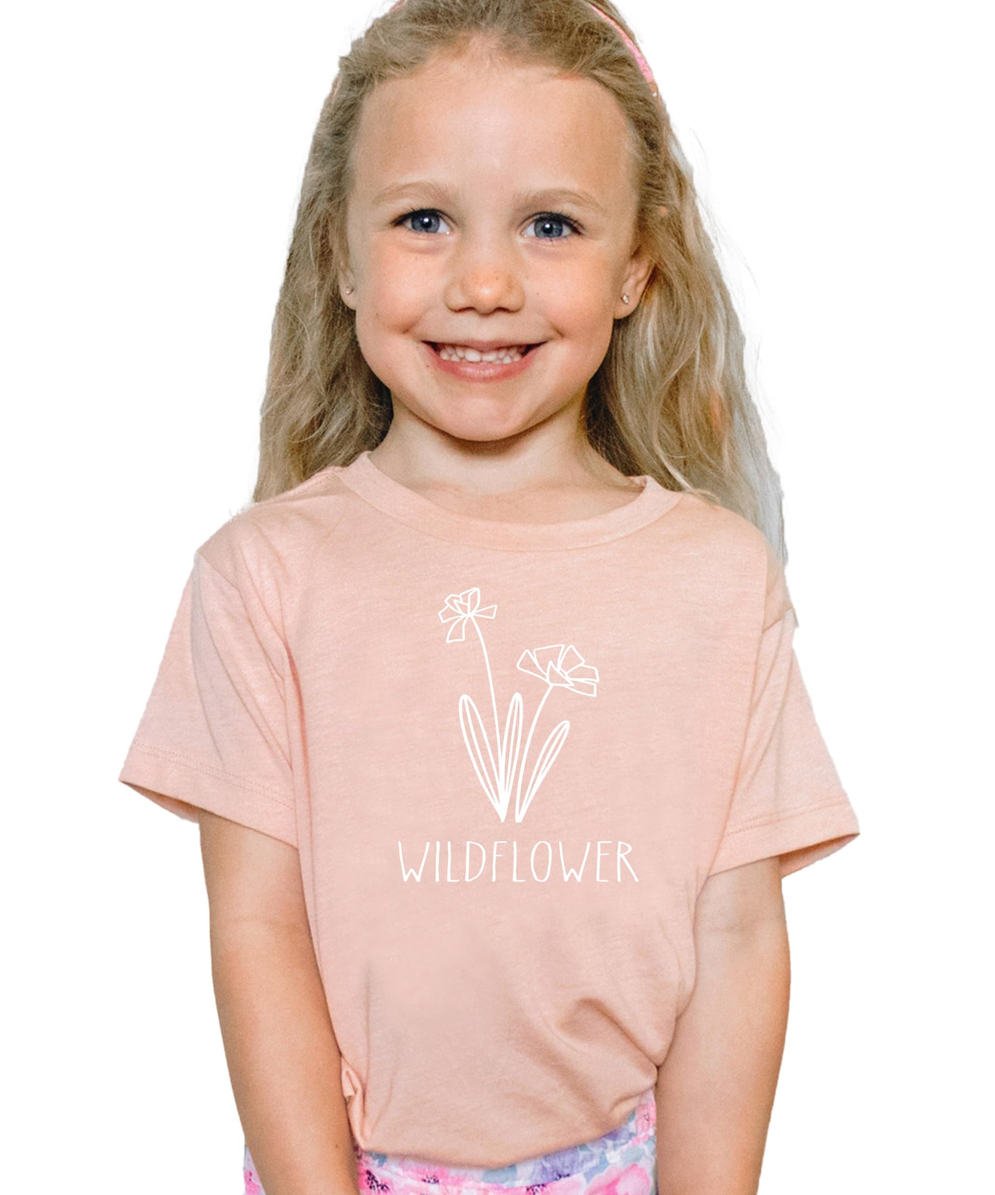 Close-up of Raising a Wildflower white graphic on mauve women's shirt