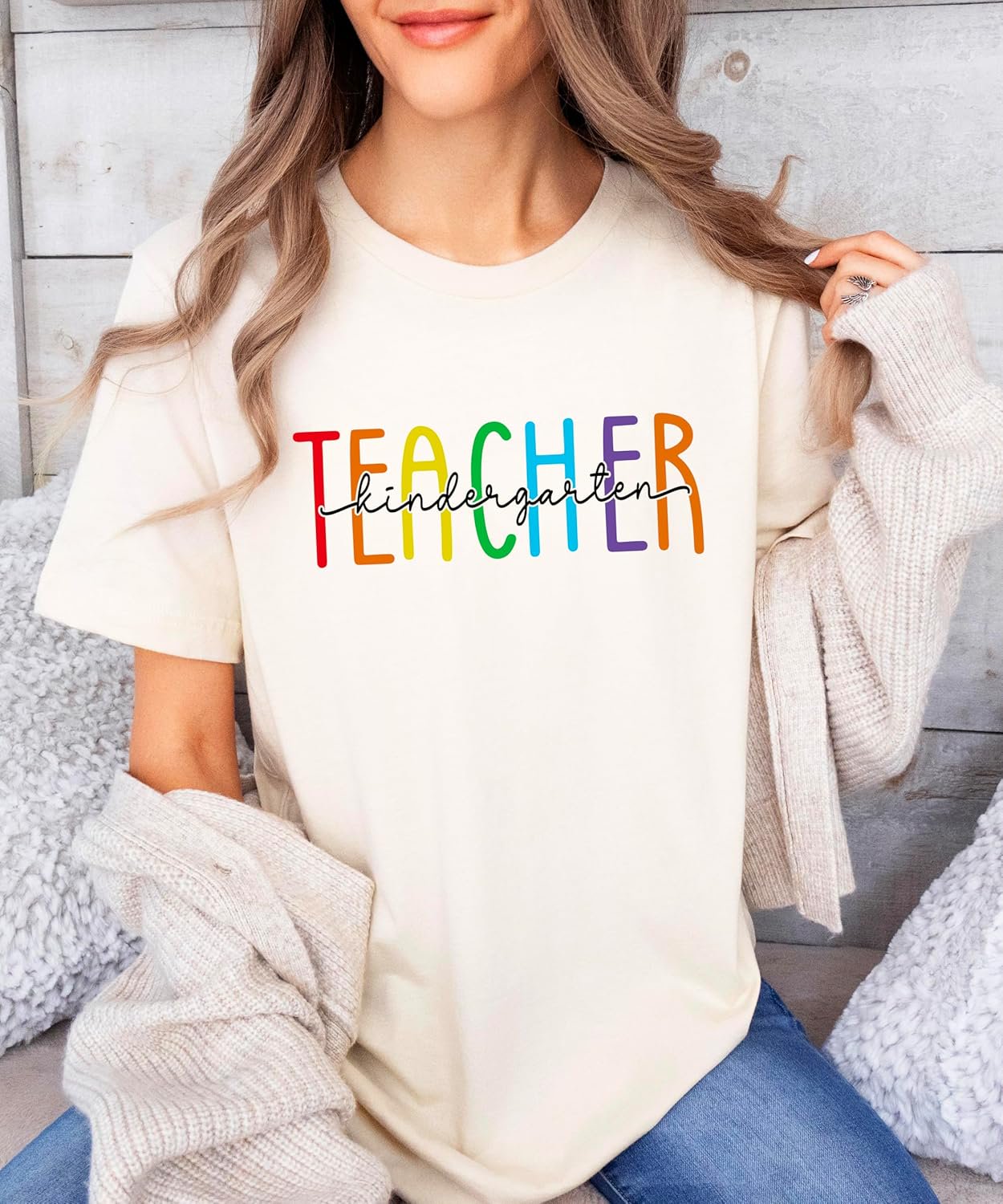 Flat lay of pink kindergarten teacher graphic tee showing full rainbow print design