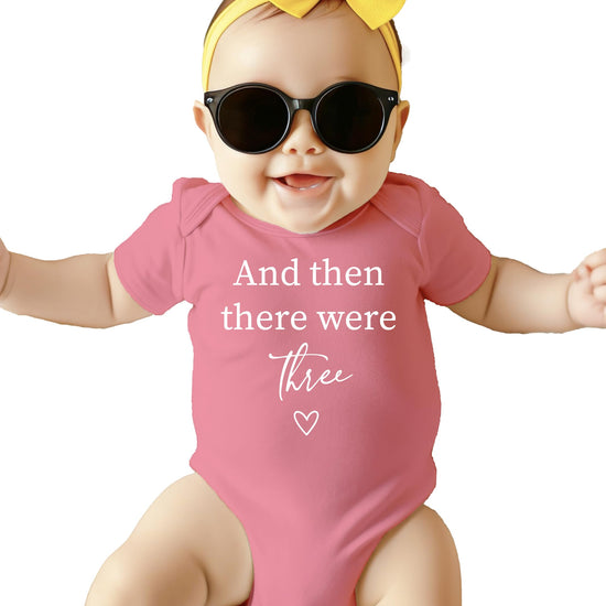 Newborn wearing mauve And Then There Were 4 baby announcement bodysuit with heart design