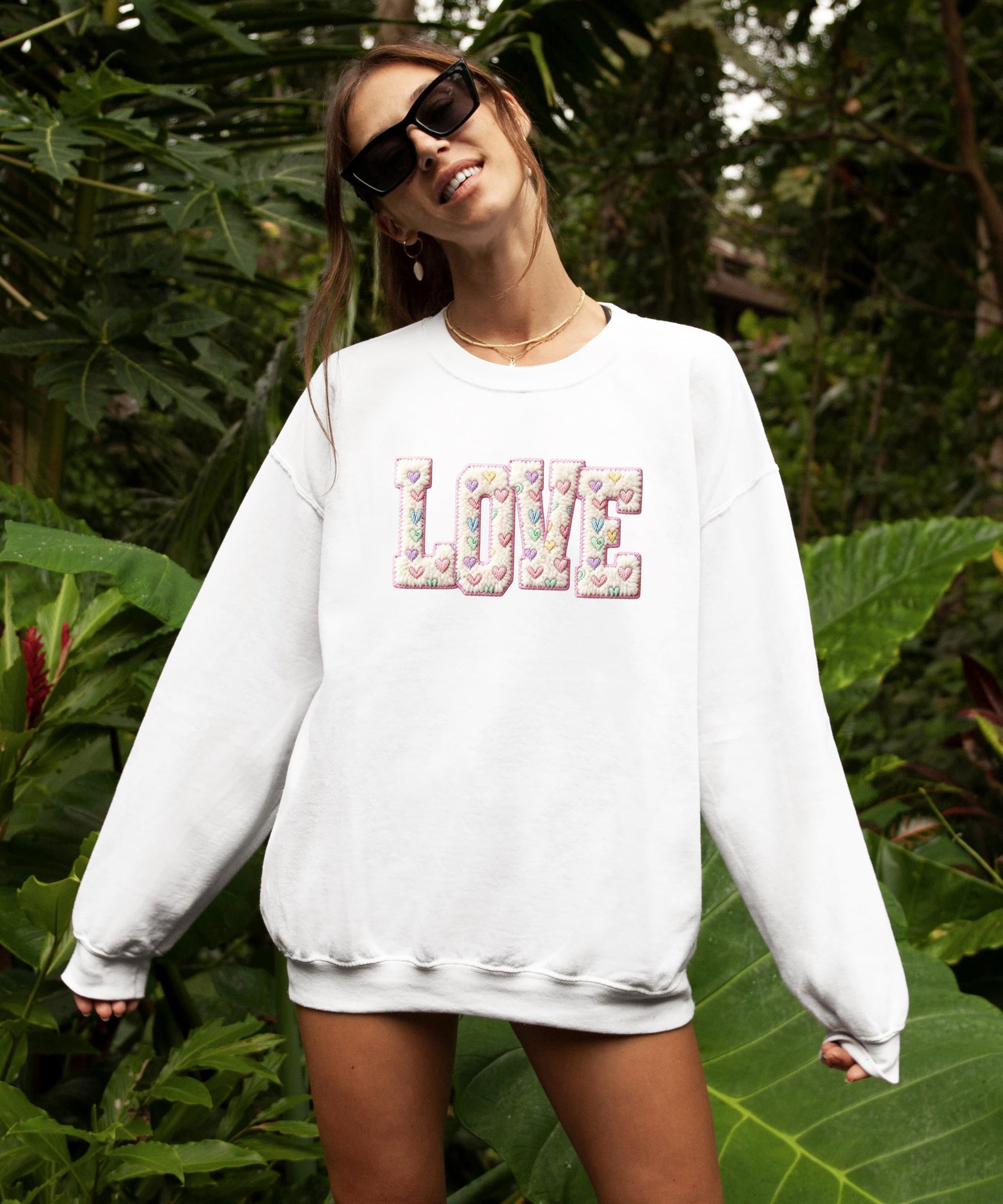 Flat lay of pink retro Valentine sweatshirt with heart graphic, styled for Valentine's Day