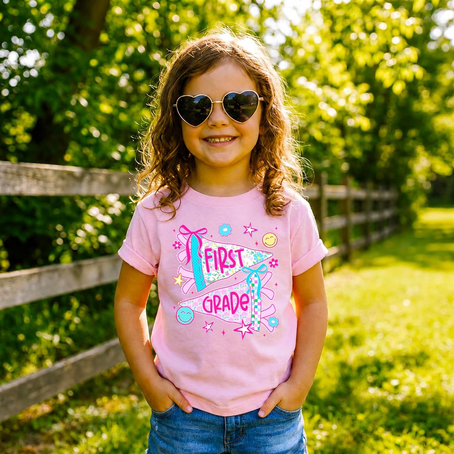 Detail shot of screen-printed first grade pennant design with stars and bow accents on girls tee