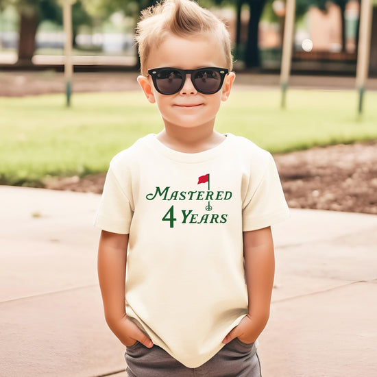 Flat lay of Mastered 4 Years kids birthday tee with golf theme graphic design