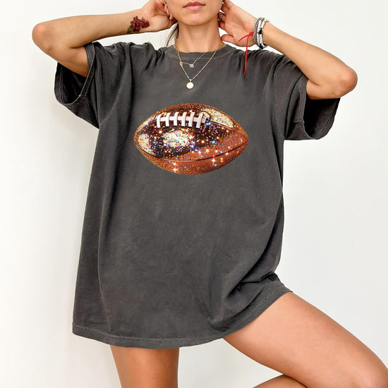 Flat lay of glitter football graphic oversized tee showing fit and fabric detail
