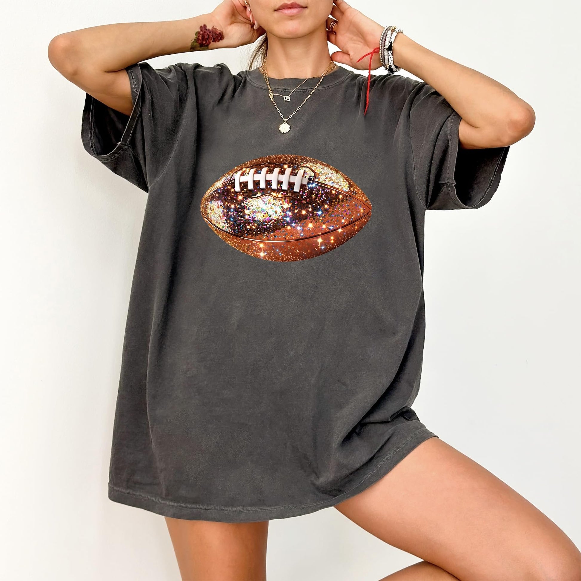 Flat lay of glitter football graphic oversized tee showing fit and fabric detail